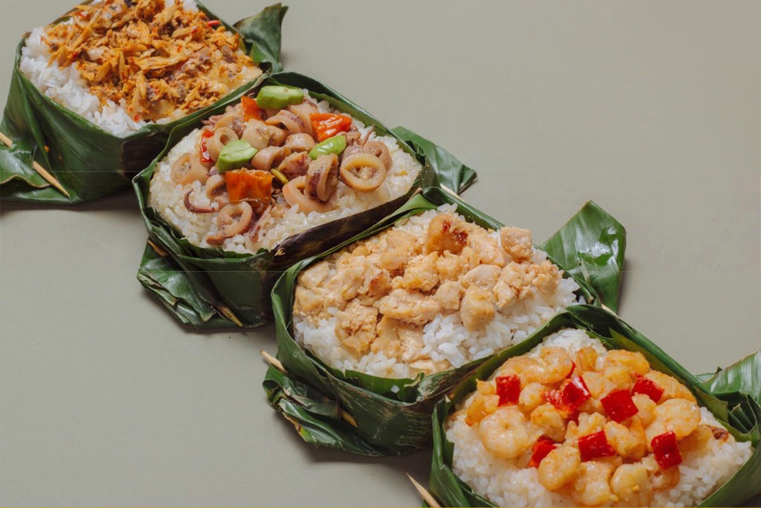 Empat nasi bakar dalam daun pisang dengan isian ikan cakalang, cumi, ayam, dan udang.